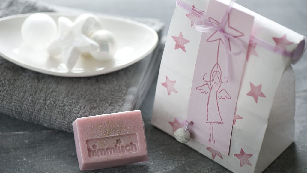 Ideen mit Seife für Weihnachten: Himmlisch! | Rosa Seifenstück mit Glitter verpackt in weißer Papiertüte mit Engel und Sternen.